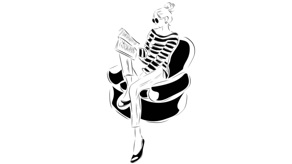 椅子に座り読書をしているサングラスをかけた女性